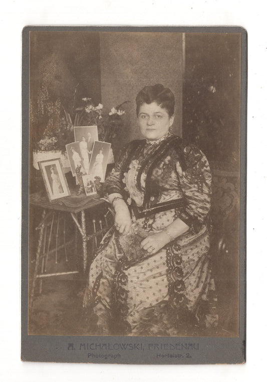 Fotografie Feine Dame am Tisch mit Fotografien / benannt - Berlin-Friedenau um 1920