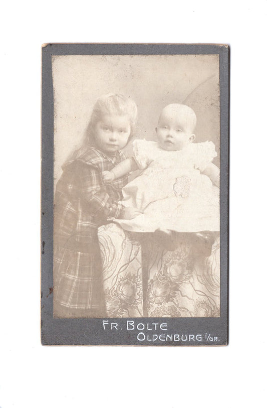 Fotografie Niedliches kleines Mädchen mit Baby / benannt - Oldenburg 1900er