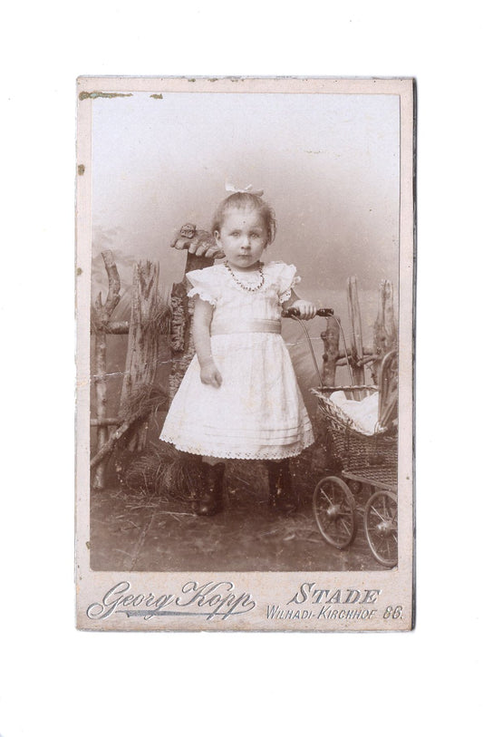 Fotografie Niedliches kleines Mädchen mit Puppenwagen - Stade 1890er